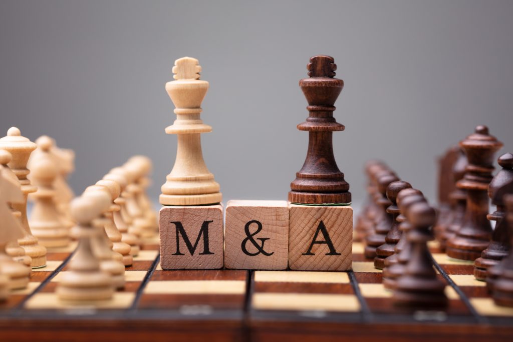 Close-up Of King Chess Pieces On Wooden Blocks With Mergers And Acquisitions
